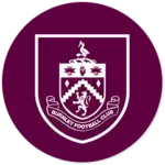 A Burnley club crest on a maroon circle