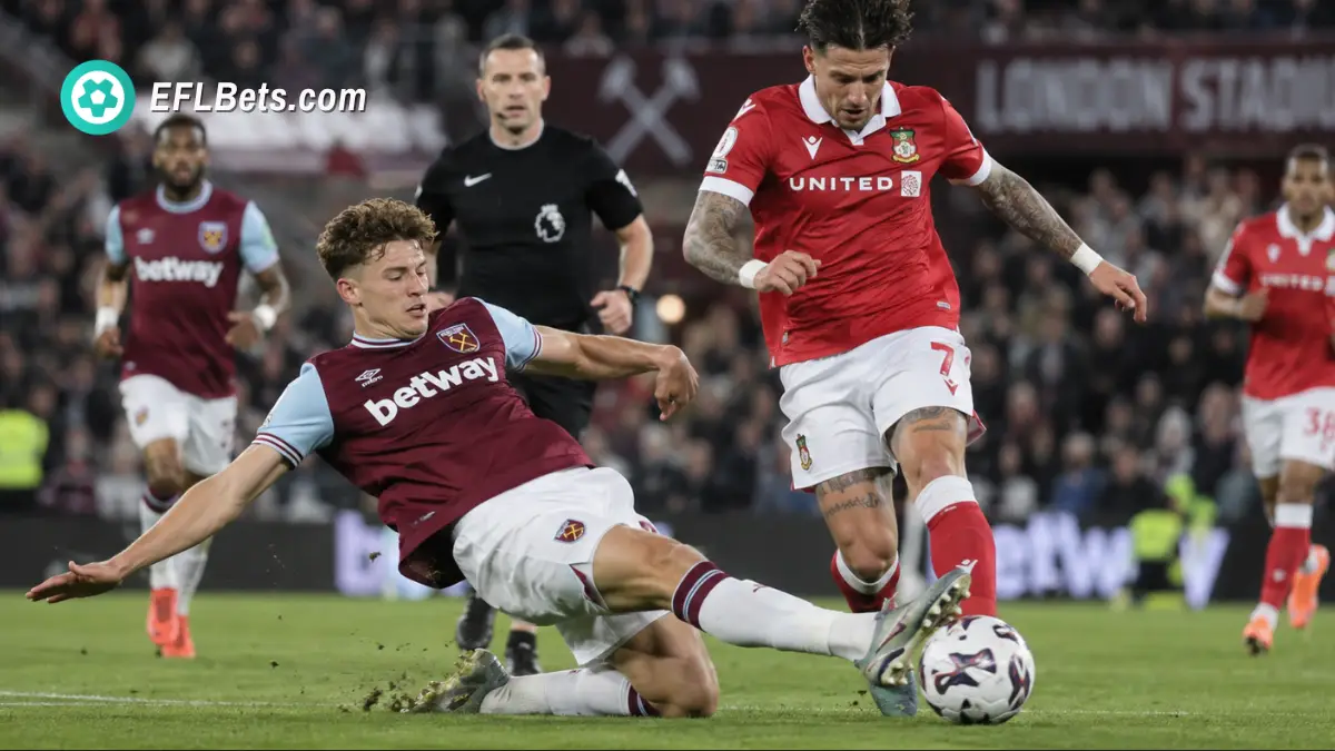 Arne Engels of West Ham United, sliding into a tackle with Josh Windass of Wrexham